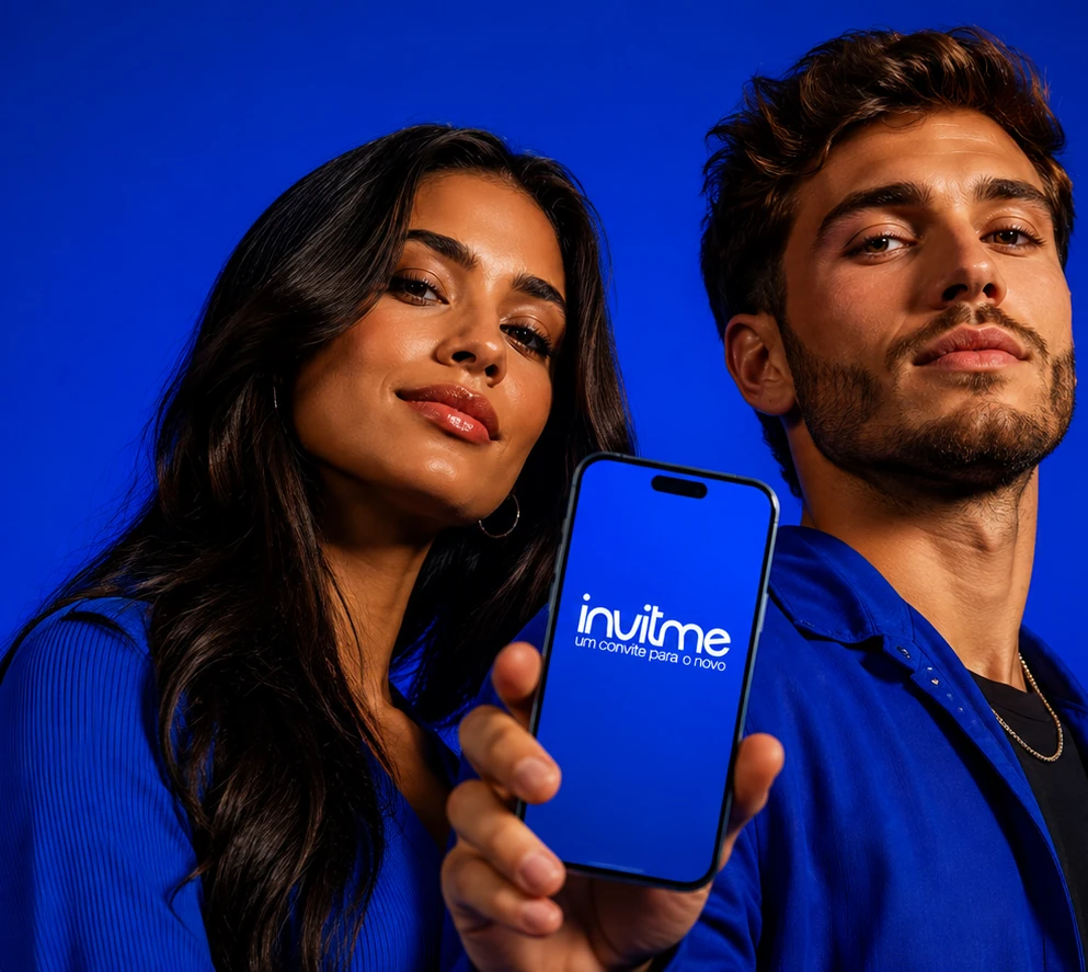Dois criadores de conteúdo mostrando o aplicativo INVITME na tela do celular